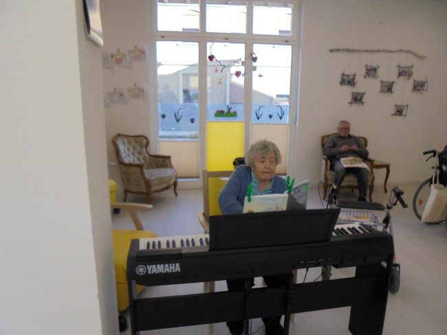 Tagesgast in der Tagespflege, spielt auf dem Piano